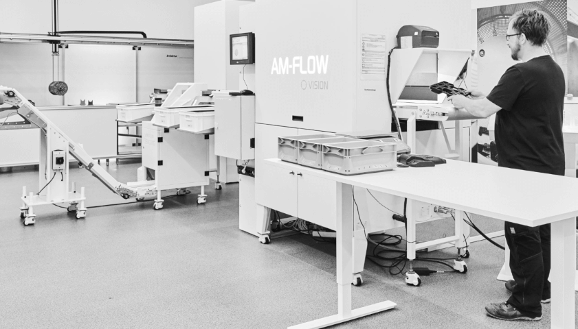 Mitarbeiter vor Sortieranlage "AM-Vision" von AM Flow beim 3D Druck Dienstleister 3Faktur.