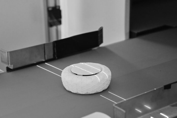 3D gedrucktes Bauteil mit Laserlinen auf Förderband zur Qualitätskontrolle