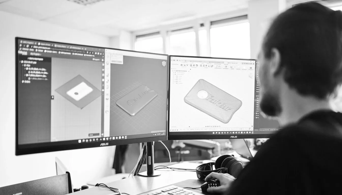Employee in front of two screens edits CAD file for 3D printing